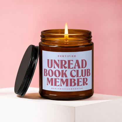 Amber jar candle with lit flame, labelled "Certified Unread Book Club Member".