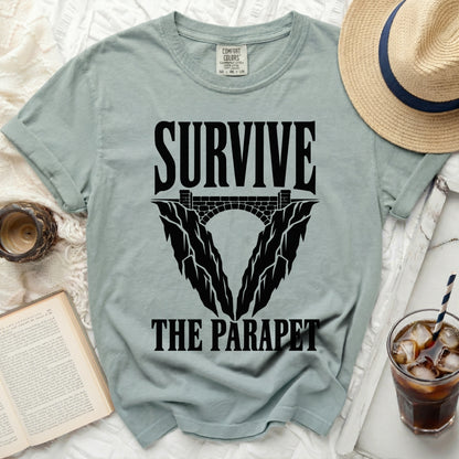 Light sage t-shirt with black text "SURVIVE THE PARAPET" and graphic.