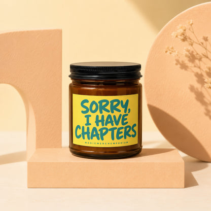 Amber jar candle with black lid and yellow label reading "SORRY, I HAVE CHAPTERS".