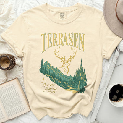 Cream t-shirt with "TERRASEN Beneath familiar stars" design featuring a stag and castle.