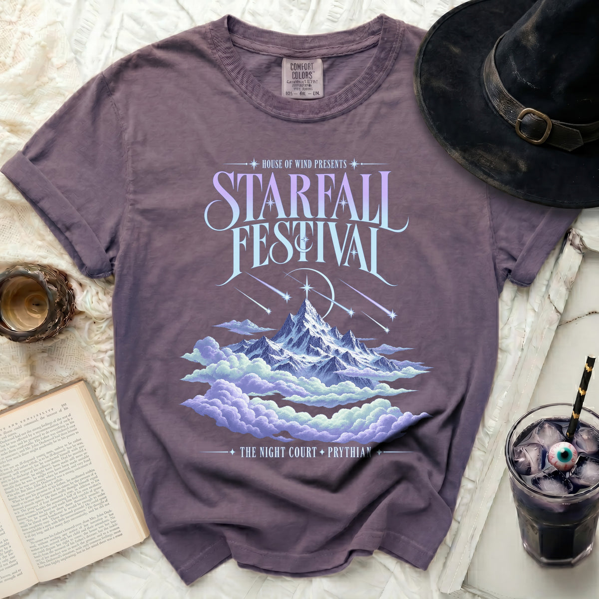 Purple Comfort Colors t-shirt with "Starfall Festival" text and mountain and cloud design.