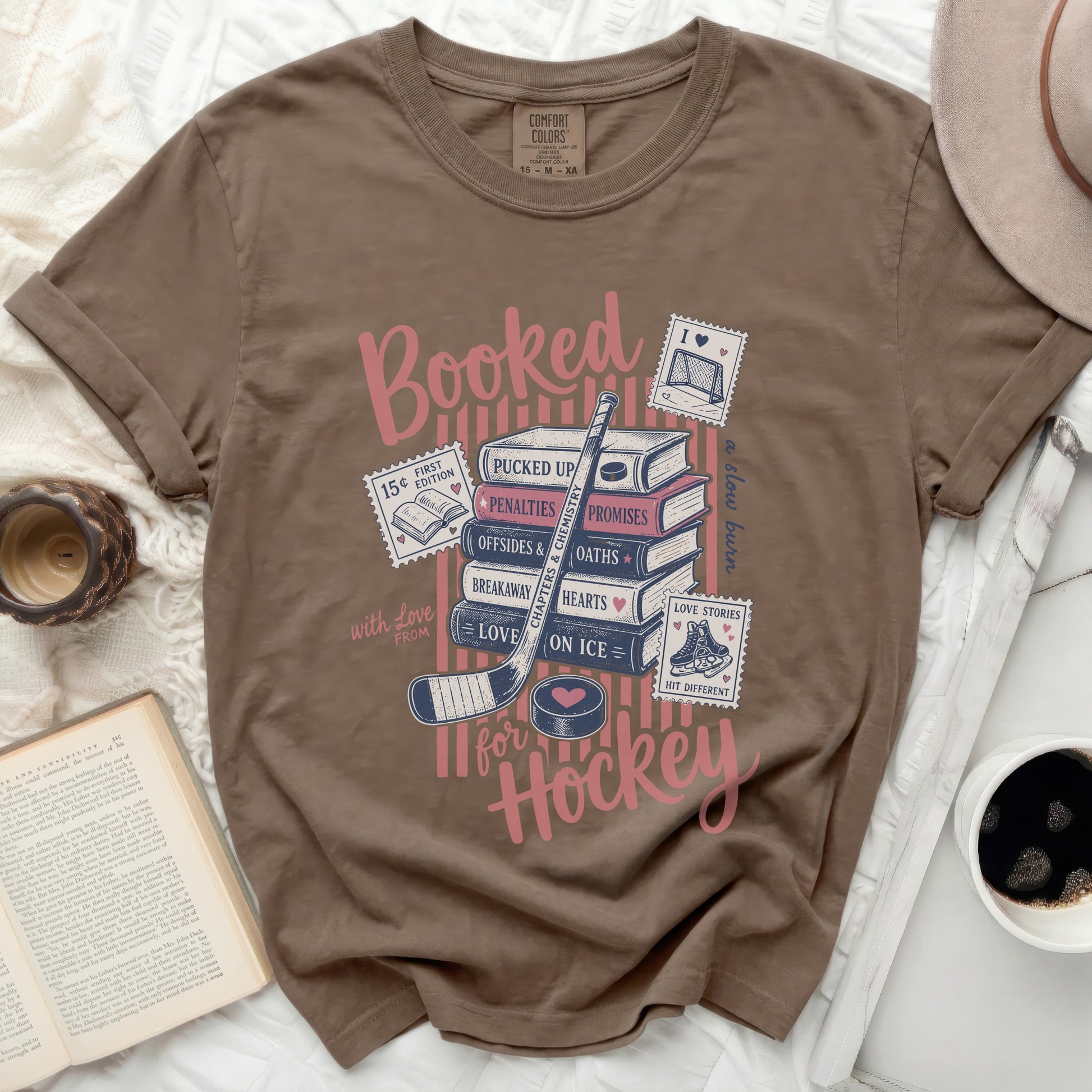 Brown t-shirt with "Booked for Hockey" text and book-themed icons.