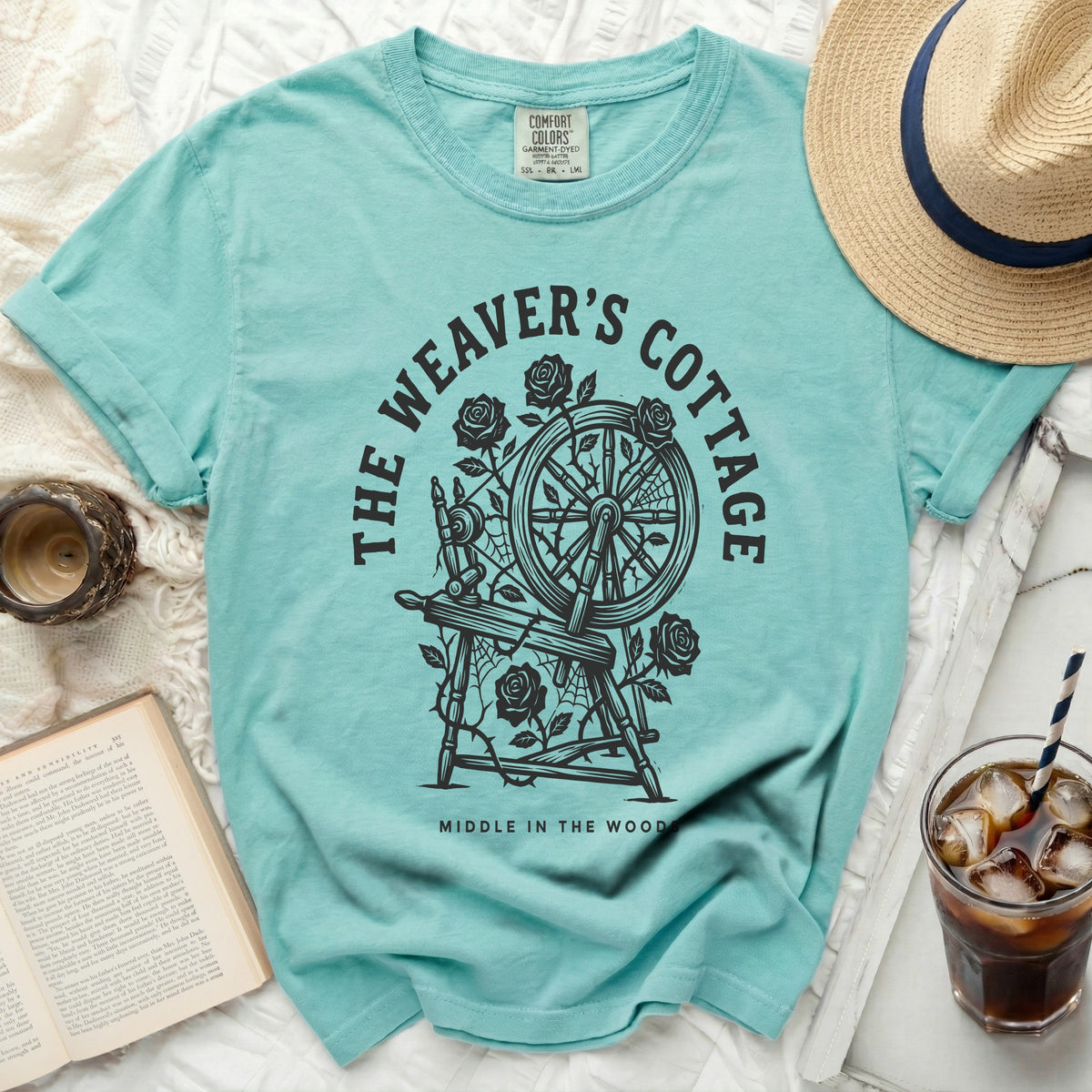 Teal t-shirt with a circular graphic of a spinning wheel, roses, and webs.