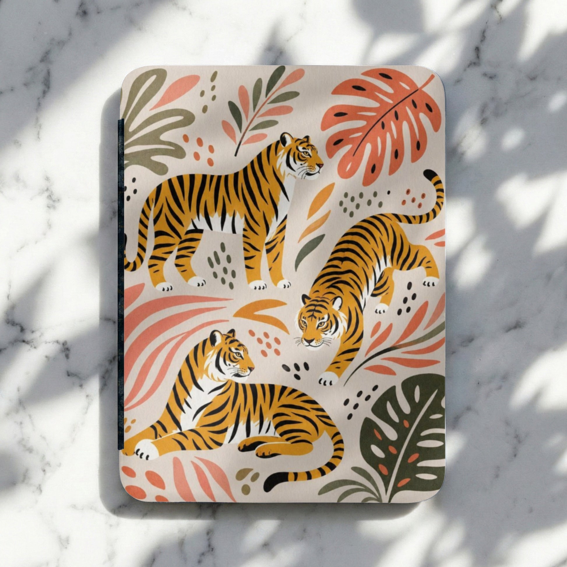 Three tigers in different poses on a cream background with coral and green botanical elements.