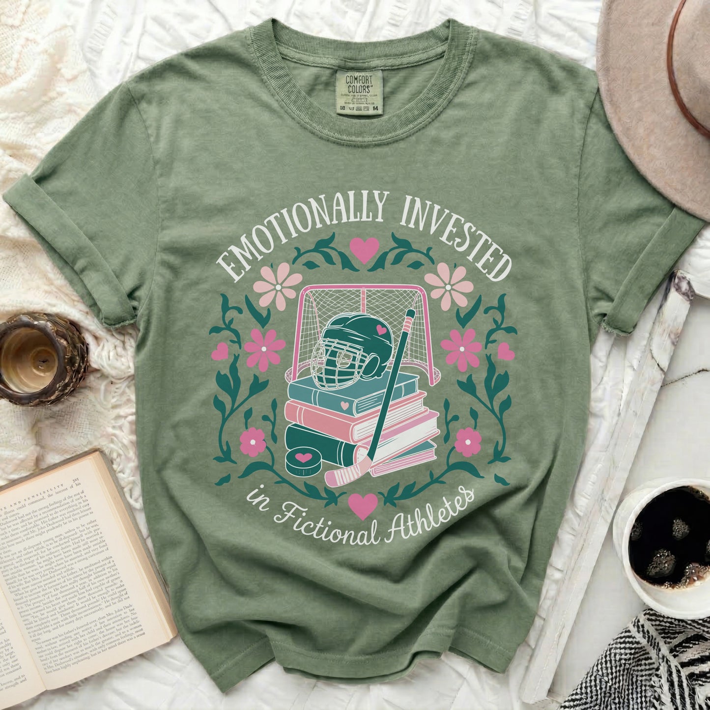 Green t-shirt with "Emotionally Invested in Fictional Athletes" text and sports graphics.