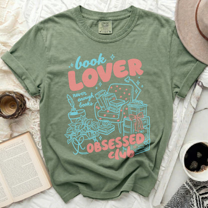 Green t-shirt with "book LOVER" and "OBSESSED CLUB" text and illustrations.