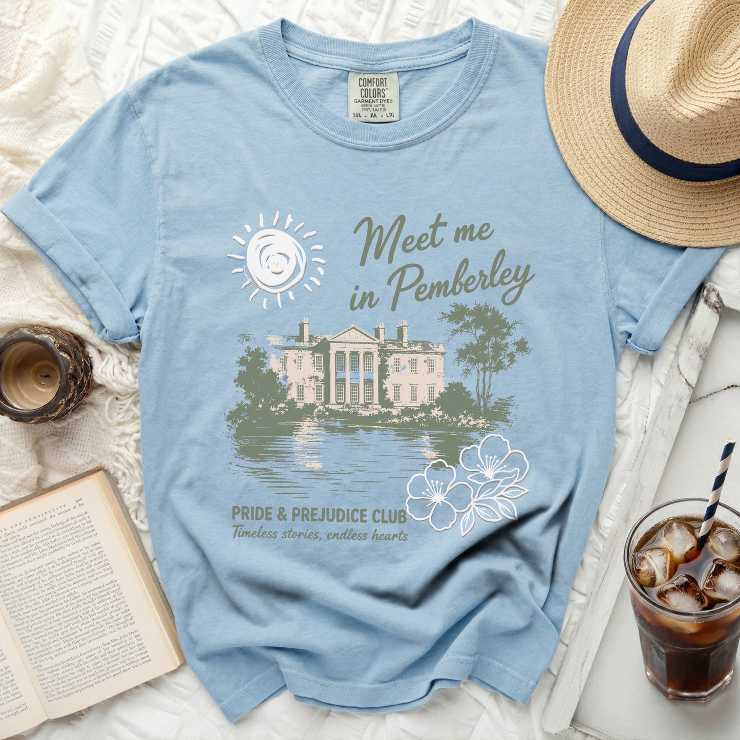 Light blue t-shirt with "Meet me in Pemberley" text and a manor scene.