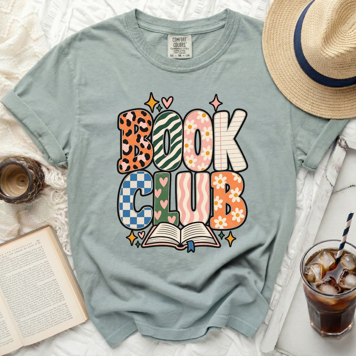 T-shirt with "BOOK CLUB" text in colorful, patterned letters and an open book.