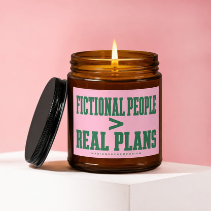 Lit candle in amber jar with pink label saying "FICTIONAL PEOPLE > REAL PLANS".