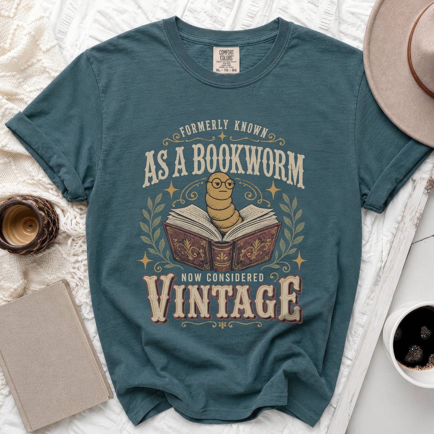 Teal t-shirt with text "Formerly Known As A Bookworm Now Considered Vintage" and a worm.