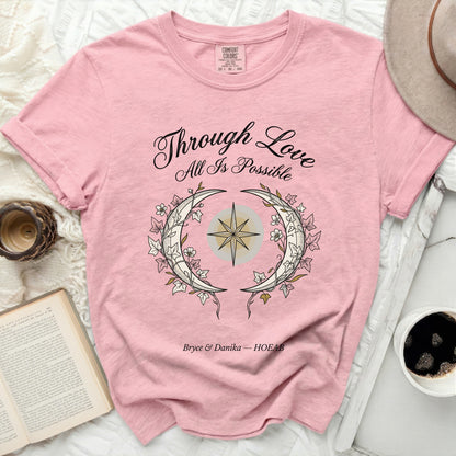 Pink t-shirt with "Through Love All Is Possible" design.