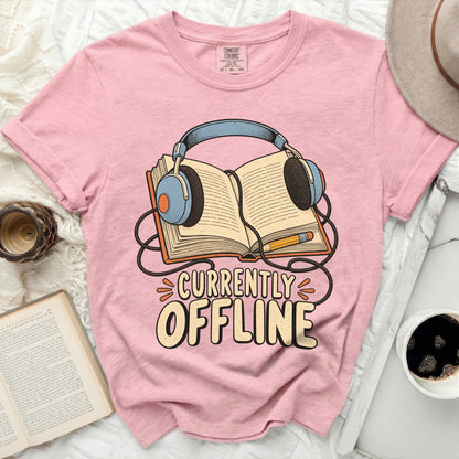 Pink t-shirt with "Currently Offline" text and headphones on an open book.