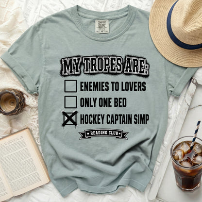 T-shirt with "MY TROPES ARE:" and a checked box next to "HOCKEY CAPTAIN SIMP".