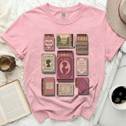 Pink t-shirt with a graphic of book-themed matchboxes.