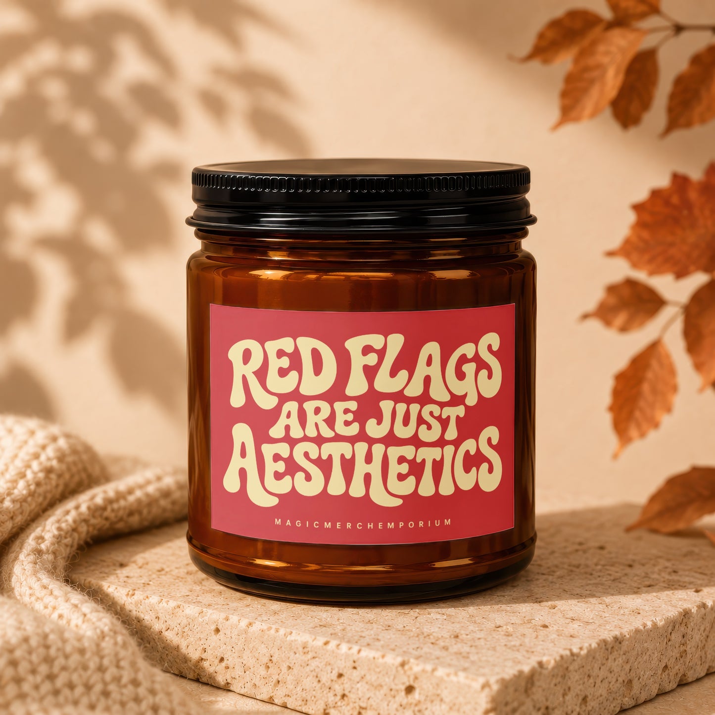 Amber candle in glass jar with red label saying "Red Flags Are Just Aesthetics".