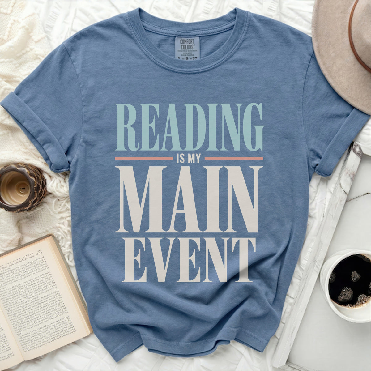 Blue t-shirt with "Reading is my main event" graphic.