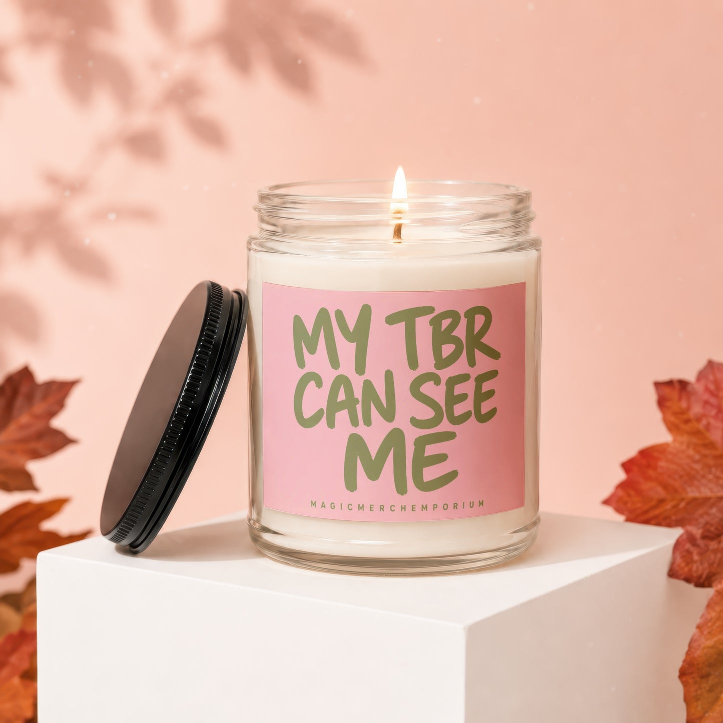 Scented candle with text "MY TBR CAN SEE ME" on a pink label.