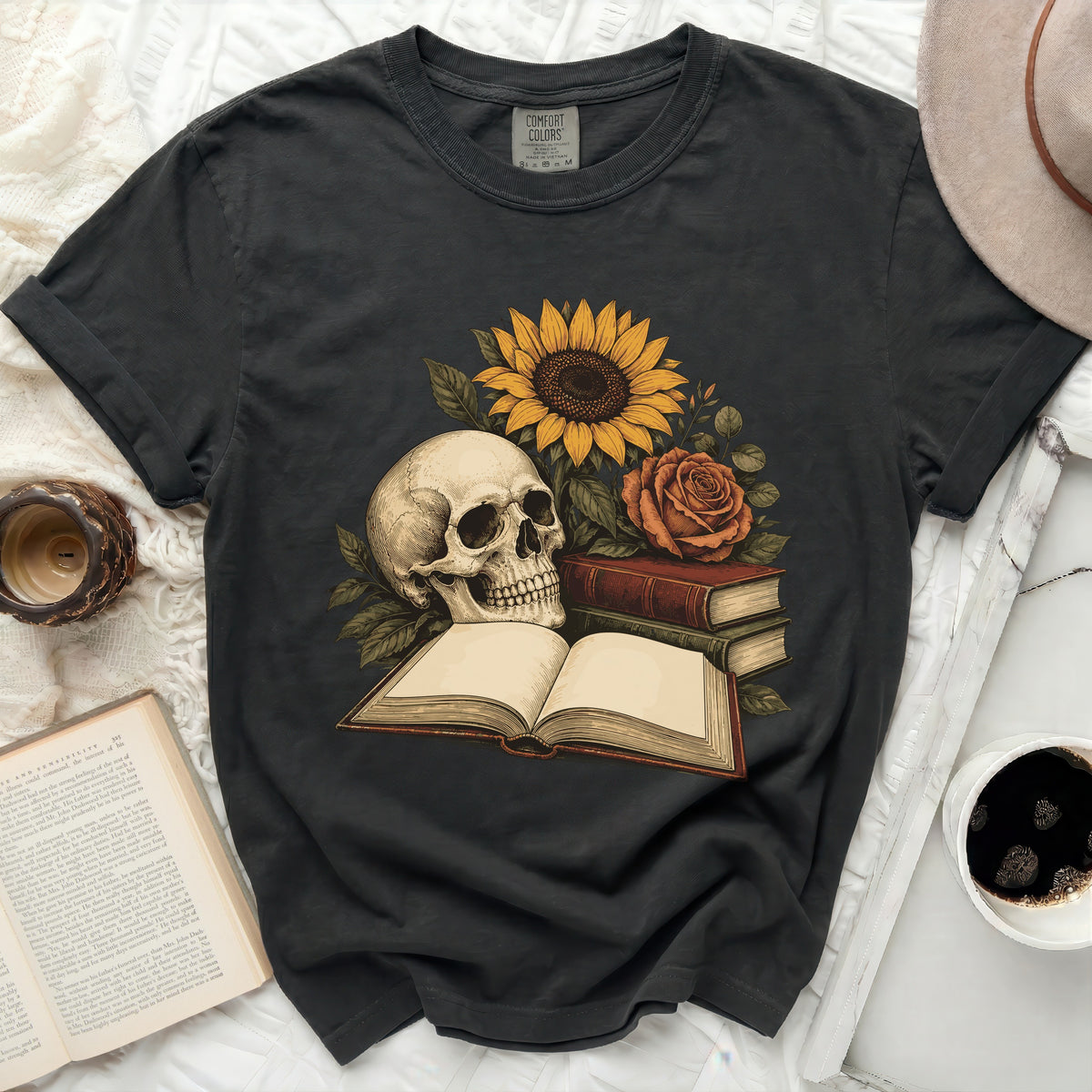 Skull with sunflower, rose, and open book graphic on a charcoal t-shirt.