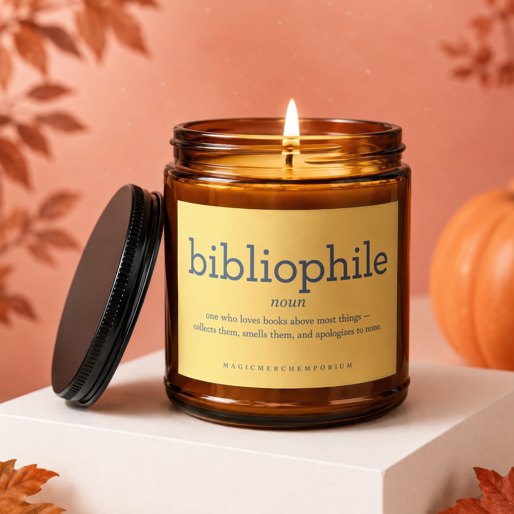 Amber jar candle with "bibliophile" definition and "MagicMerchEmporium" text.