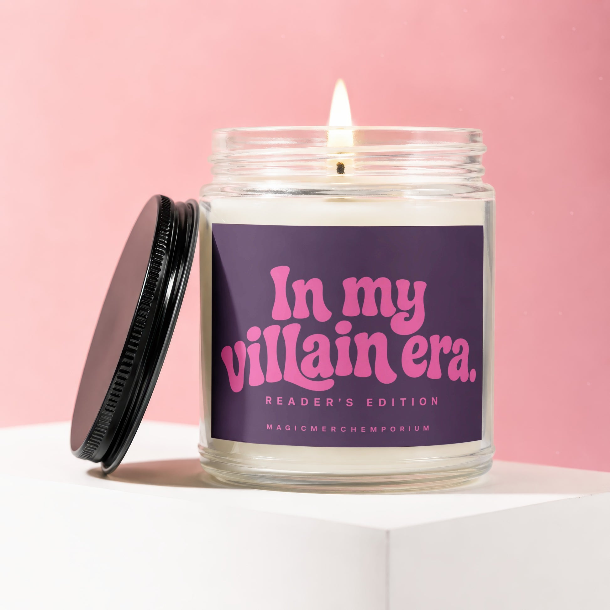 Lit candle in glass jar with purple label reading "In my villain era. Reader's Edition."
