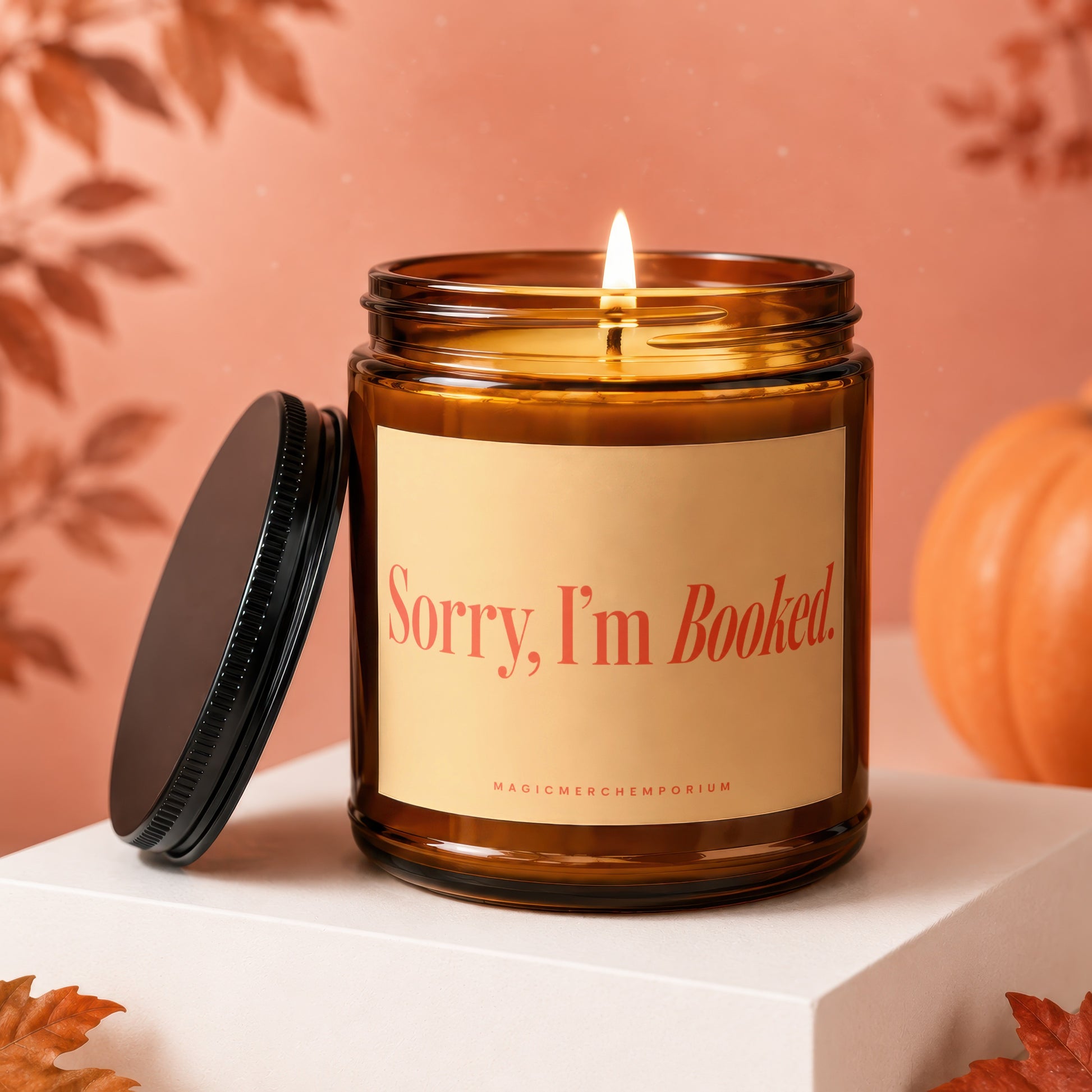 Amber jar candle with lit wick, "Sorry, I'm Booked" text, and black lid.