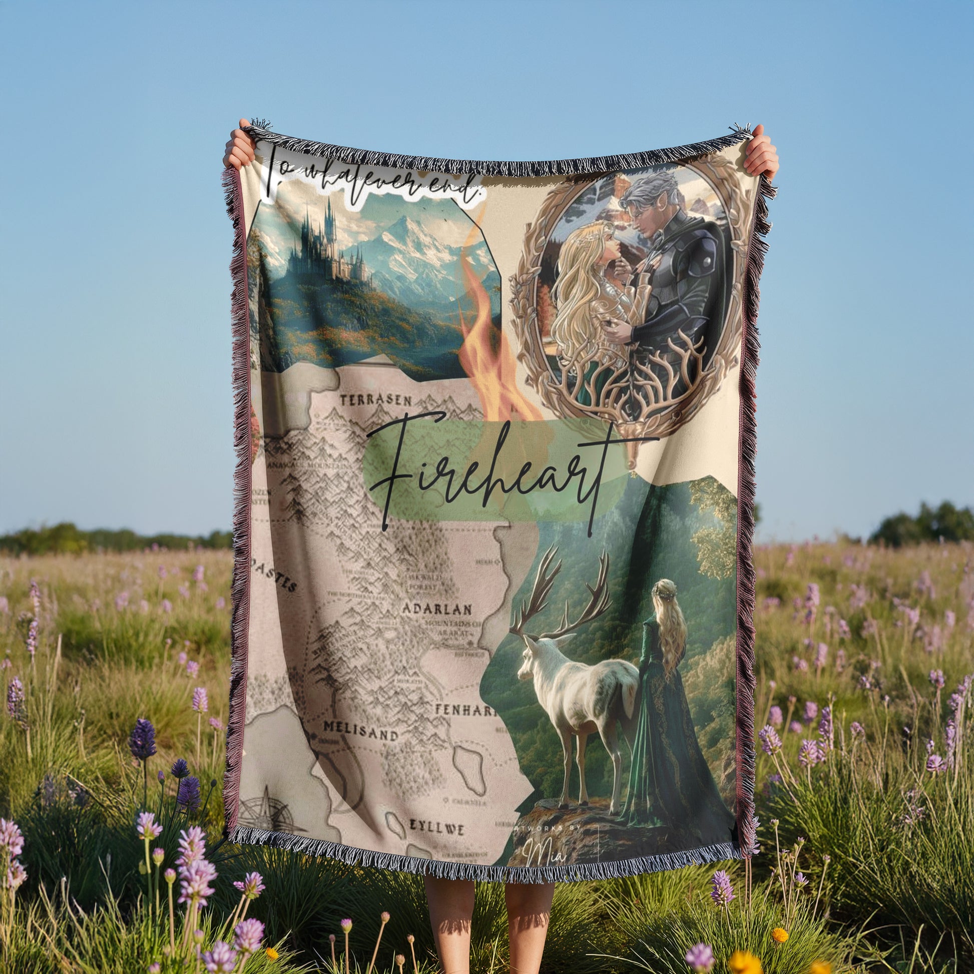 A person is holding up a large blanket with a map and various images, including a castle, a woman, and a deer, in a field with purple flowers.