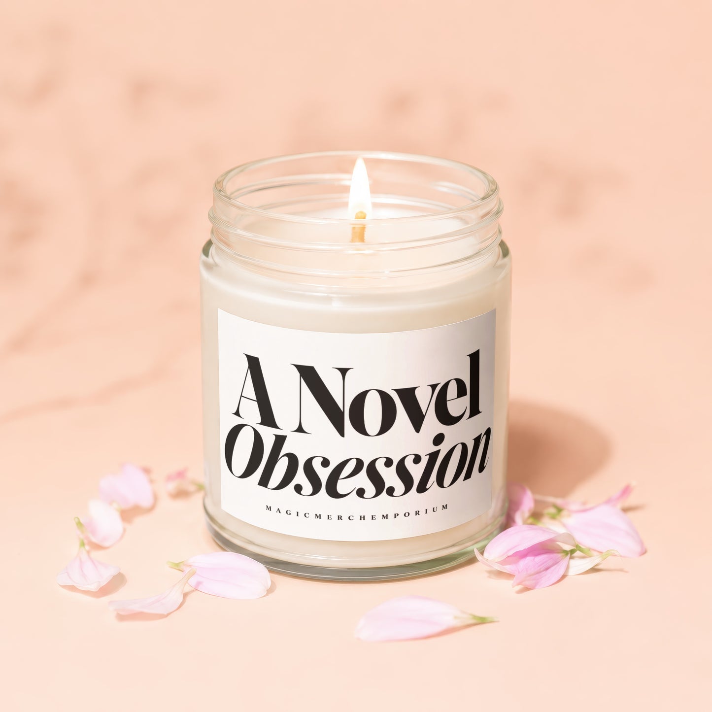 Candle with "A Novel Obsession" text on label with pink petals.