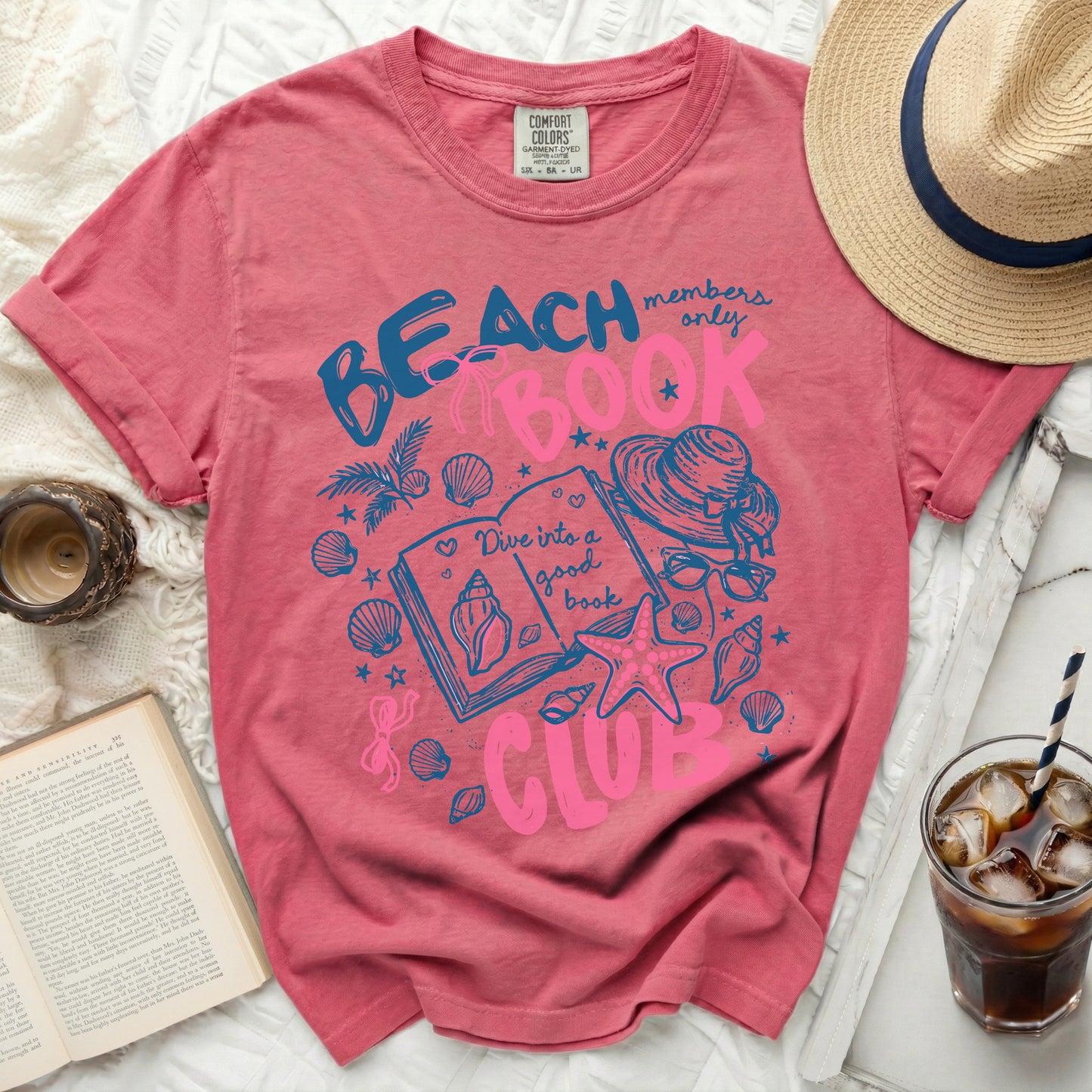 Pink t-shirt with "Beach Book Club" graphic and seashells.