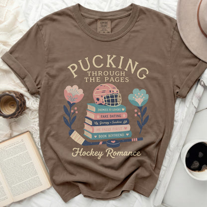 T-shirt with "Pucking Through the Pages" text and hockey romance themes.