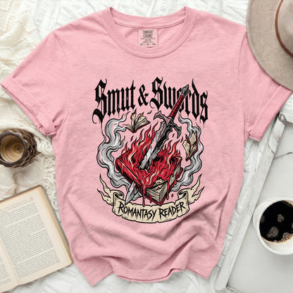 Pink t-shirt with "Smut & Swords" and flaming book graphic.