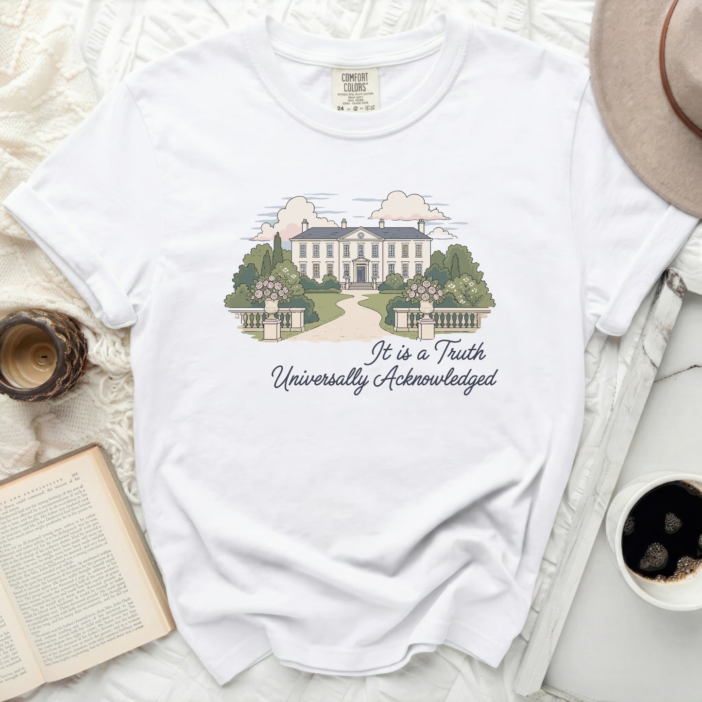White t-shirt with illustration of a manor house and text "It is a Truth Universally Acknowledged".