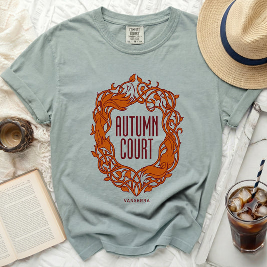 Light blue t-shirt with "Autumn Court" text and ornate design.