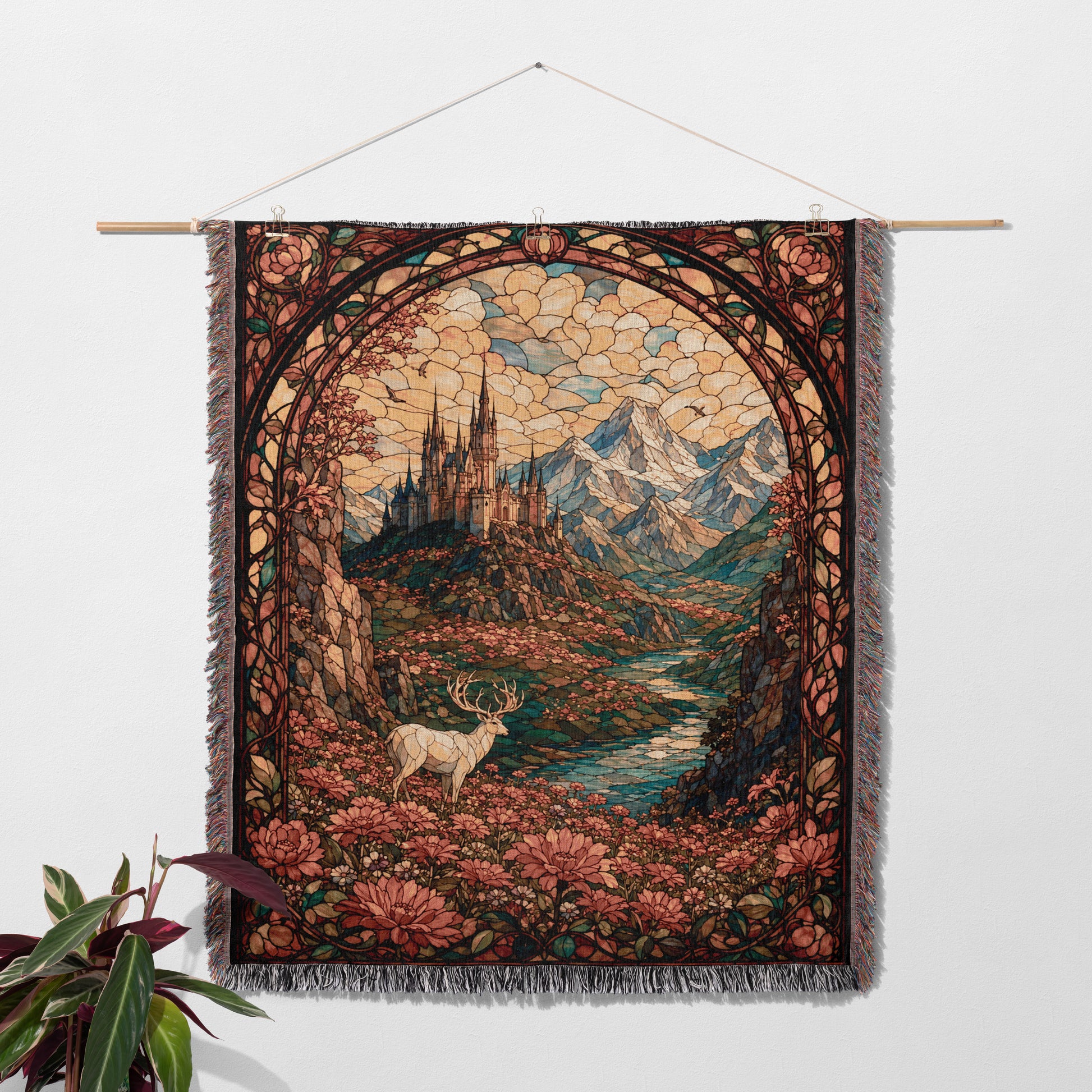 a tapestry hanging on a wall, depicting a serene landscape with a deer standing in the foreground and mountains in the background.