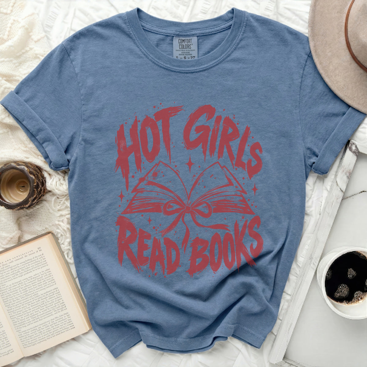 Blue t-shirt with red text and graphic of an open book.