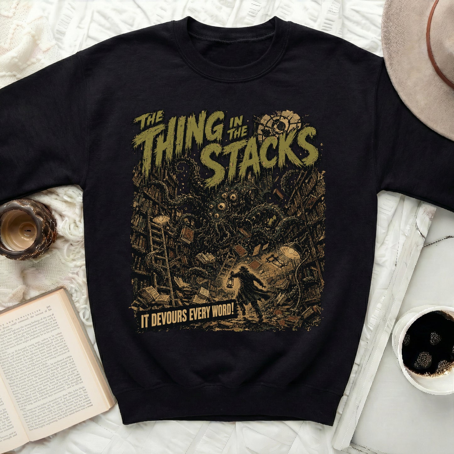 Black sweatshirt with "The Thing in the Stacks" and a monster.