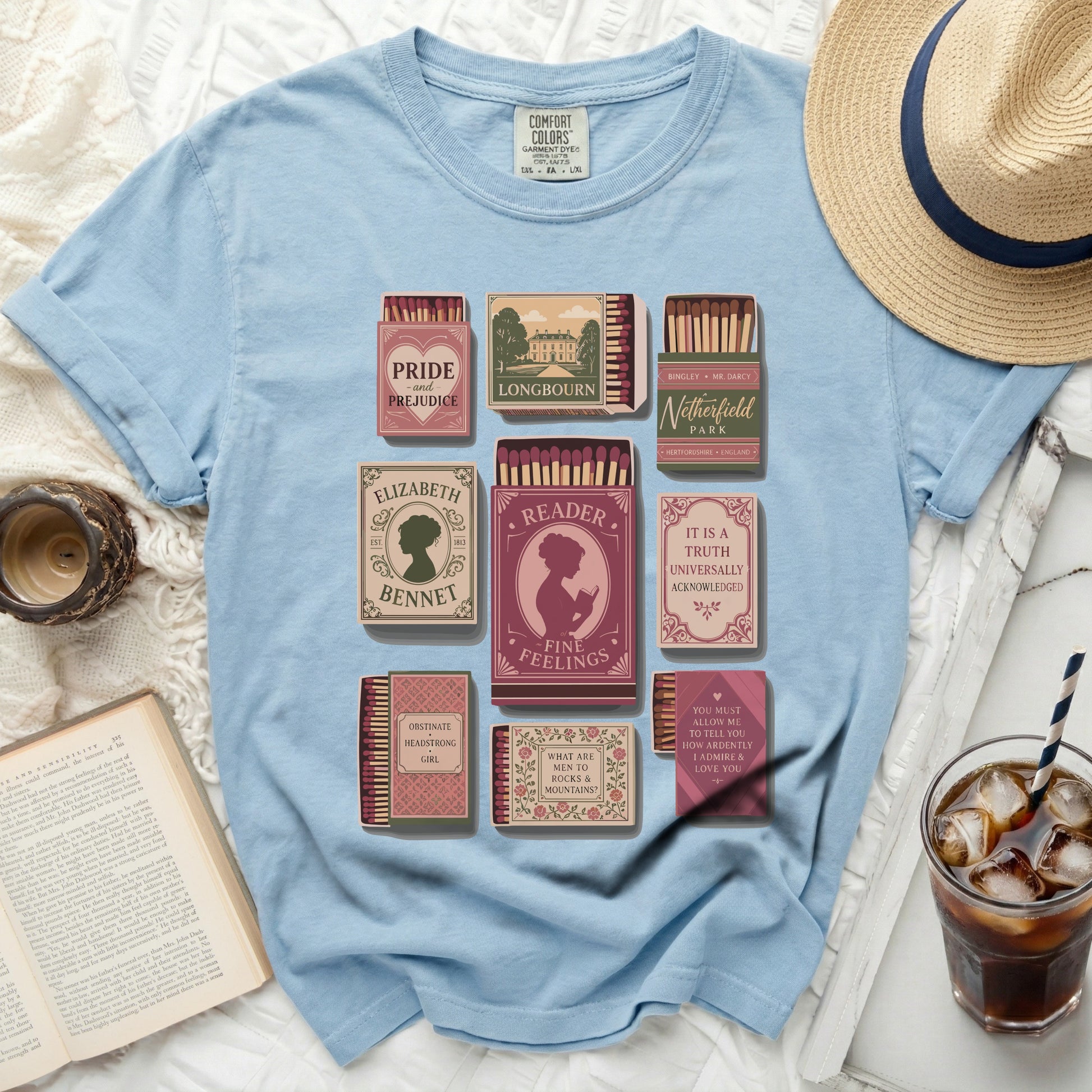 Light blue t-shirt with literary matchbox designs: Pride and Prejudice, Elizabeth Bennet, and more.