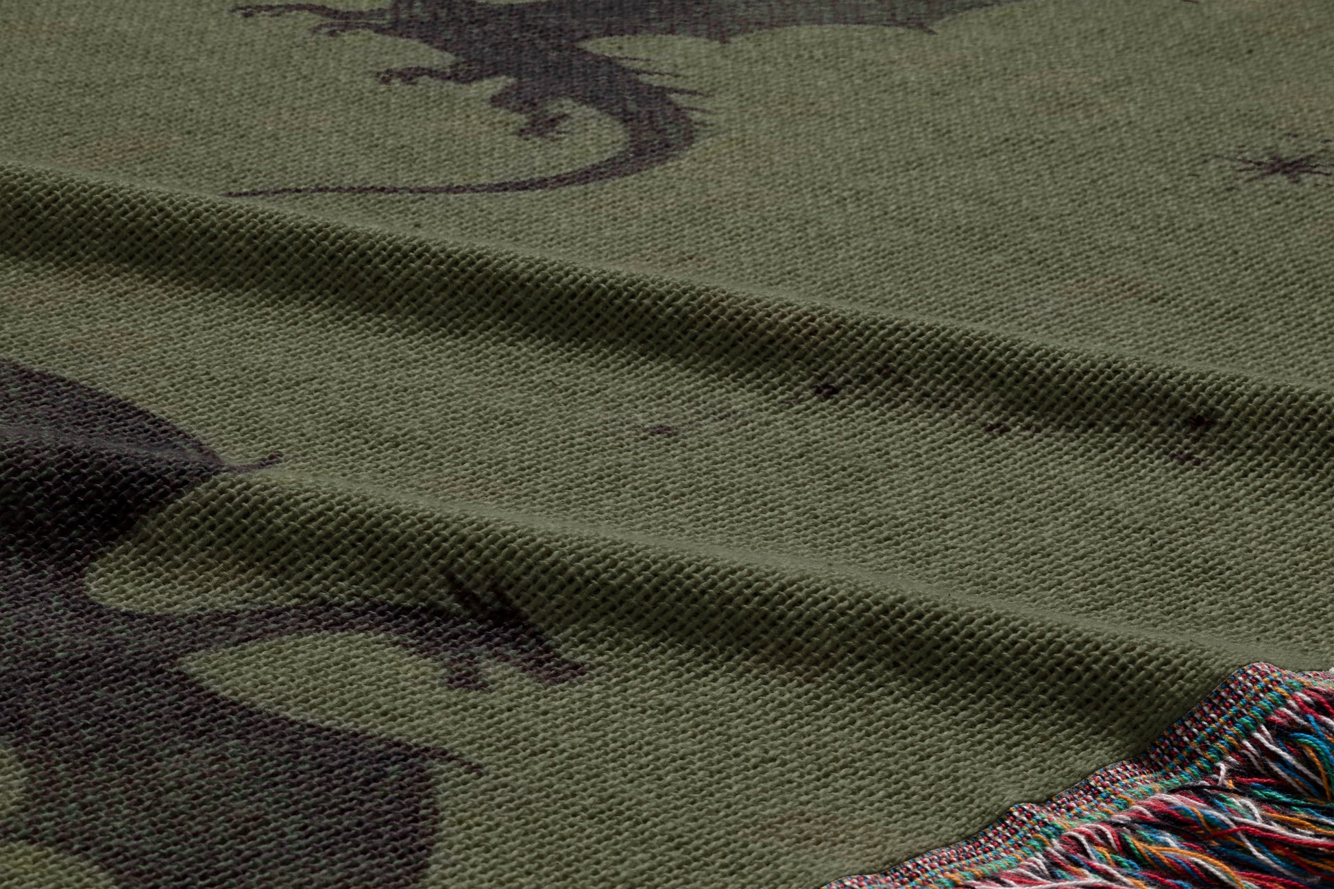 a close-up view of a textured fabric with a dragon design on it. The dragon appears to be a dark silhouette against a lighter background, creating a striking contrast.