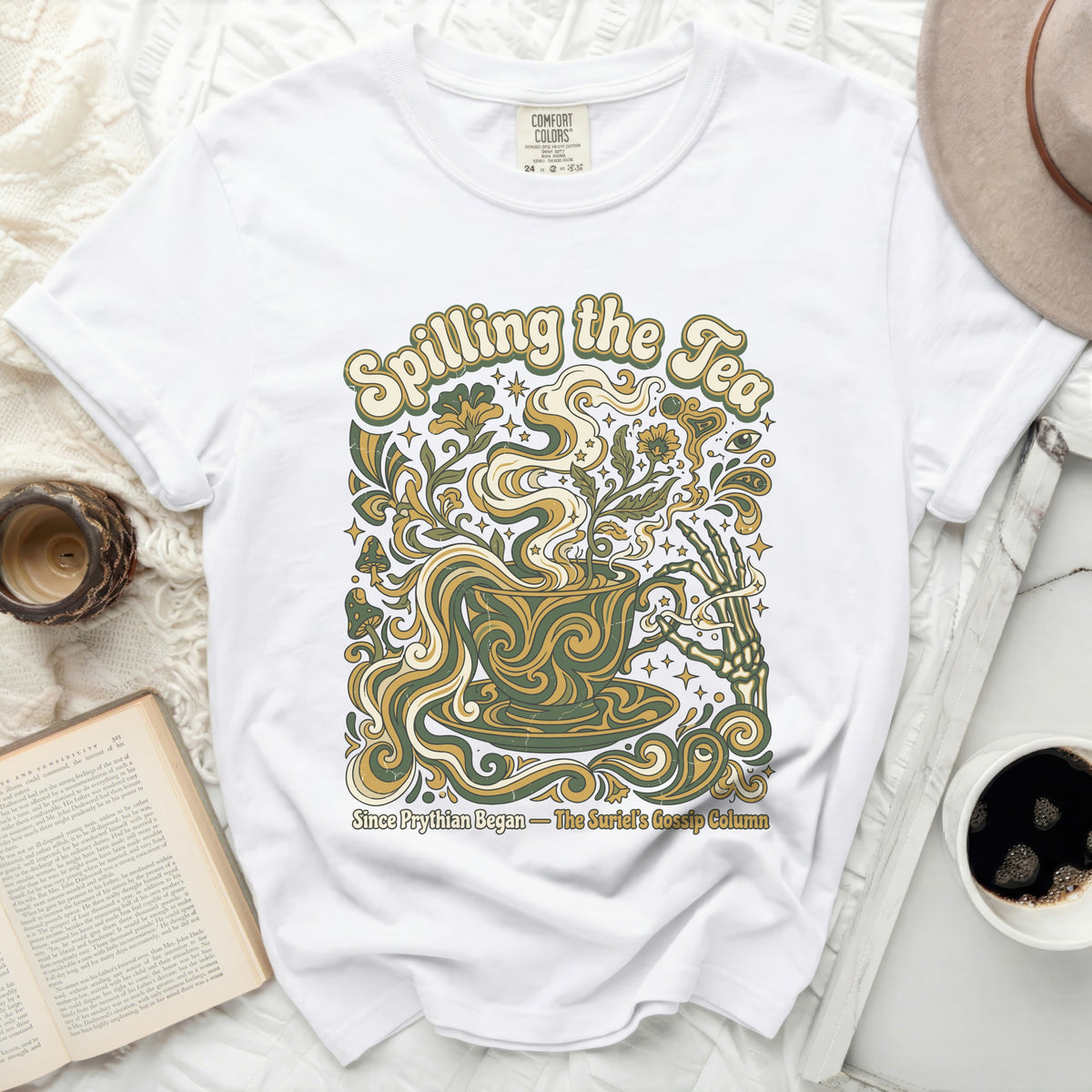 White t-shirt with "Spilling the Tea" and floral skeleton hand graphic.