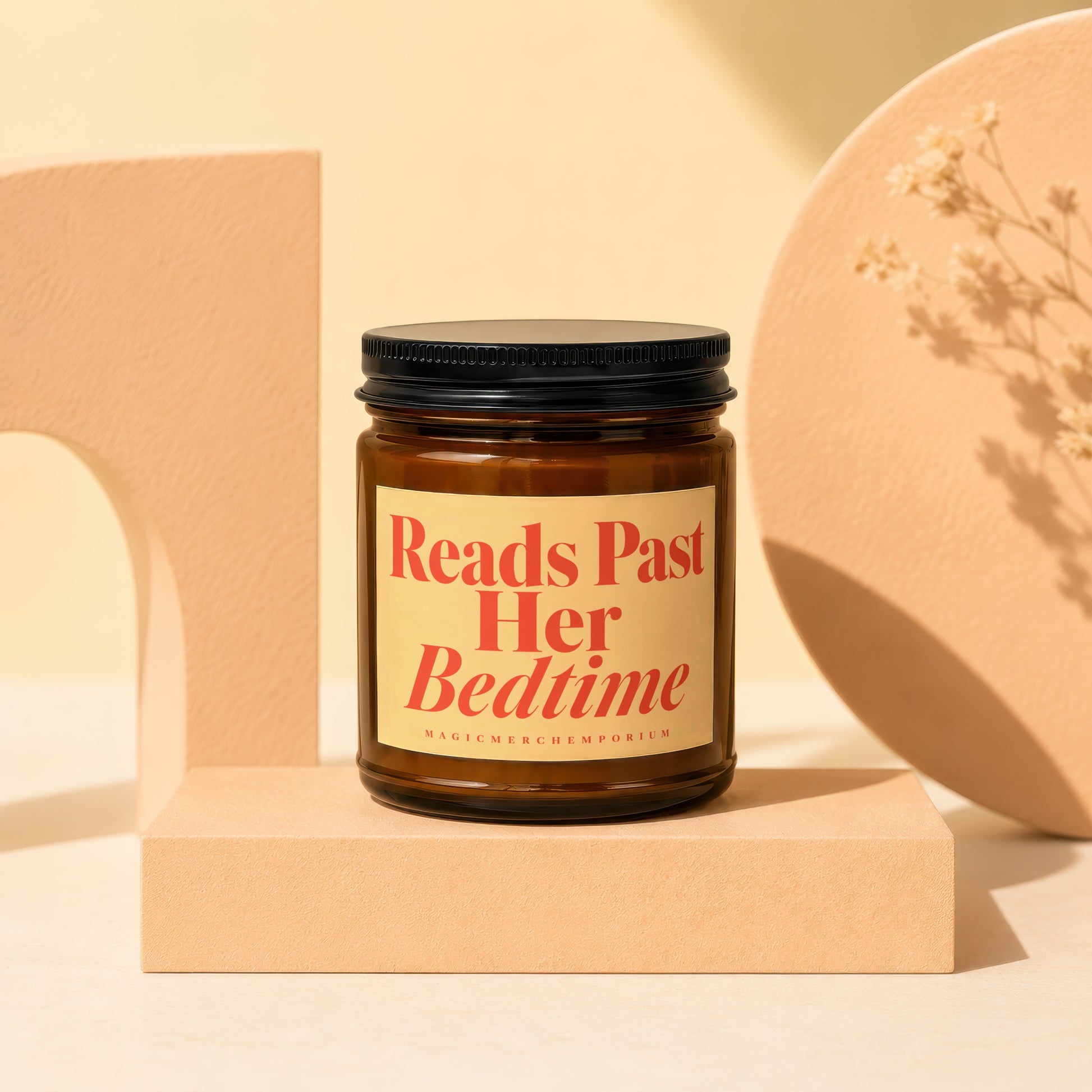 Brown glass candle with "Reads Past Her Bedtime" label and "MagicMerchEmporium" text.