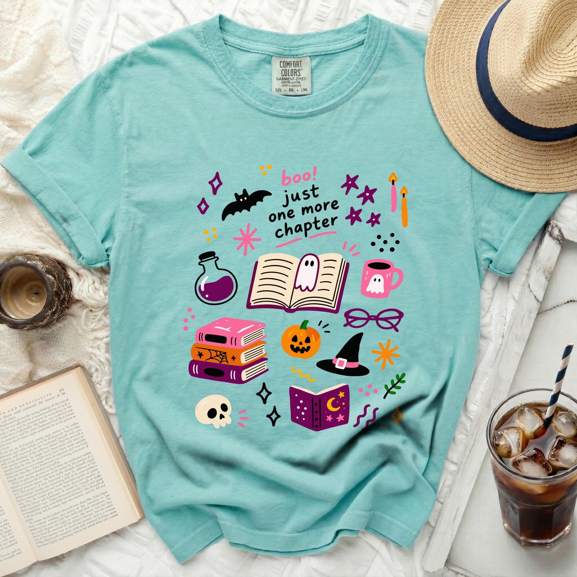Teal t-shirt with "boo! just one more chapter" and Halloween illustrations.
