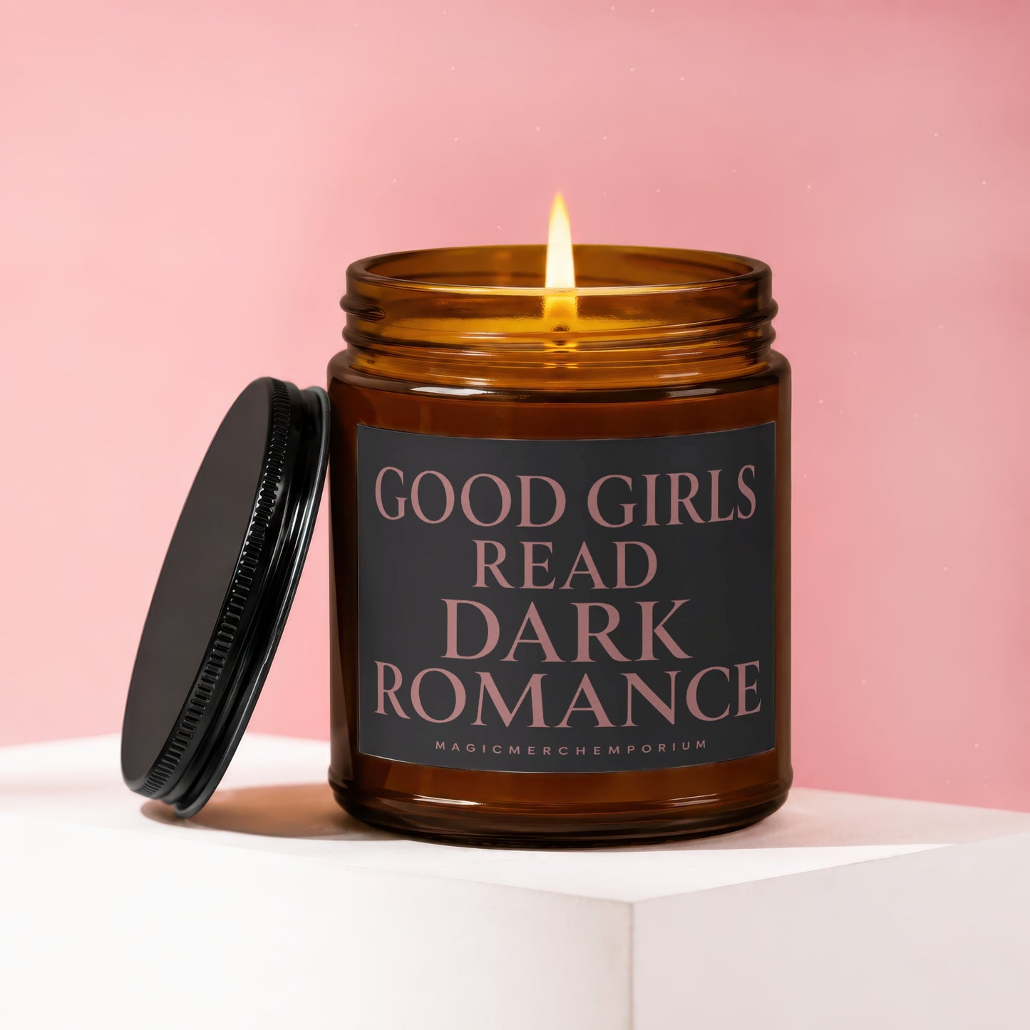 Amber jar candle with lid off, lit flame. Text: GOOD GIRLS READ DARK ROMANCE.