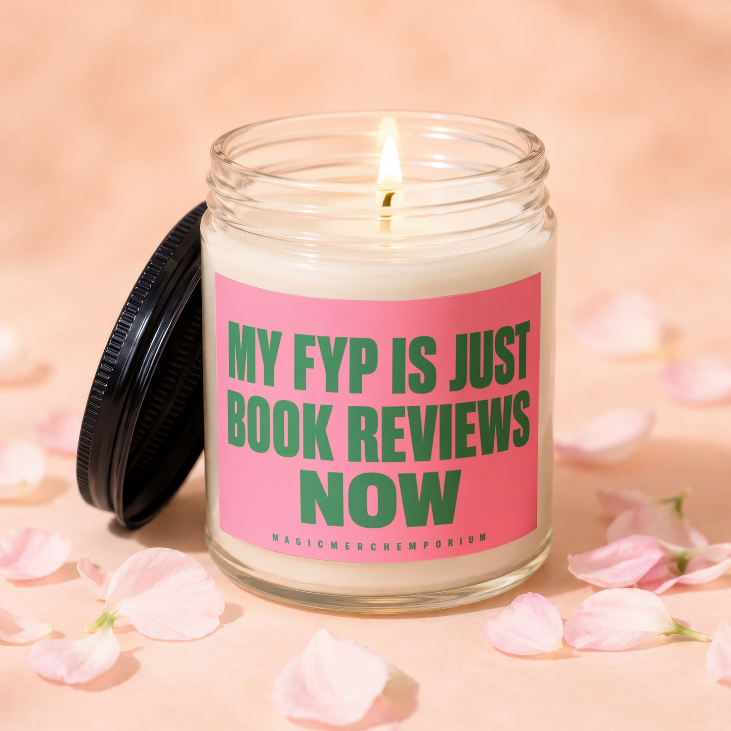 Glass candle with lit wick and pink label reading "My FYP is Just Book Reviews Now".