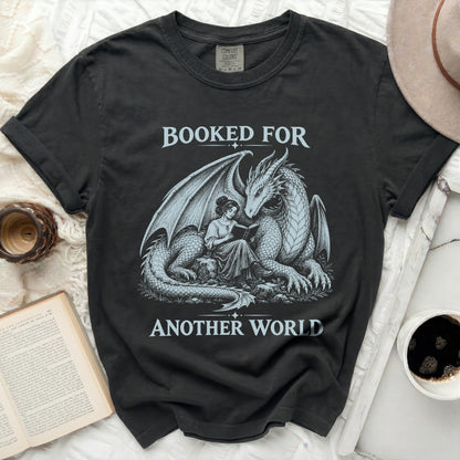 Black t-shirt with dragon and woman reading graphic, "Booked For Another World" text.
