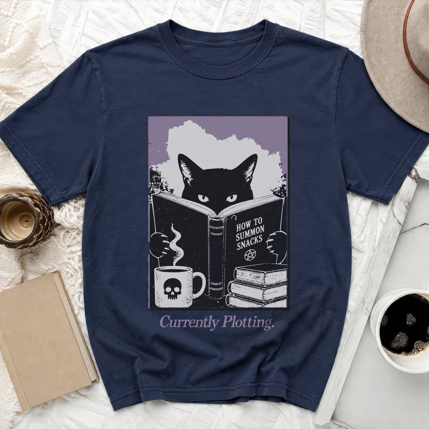 Navy t-shirt with a black cat reading "How to Summon Snacks" by a skull mug.