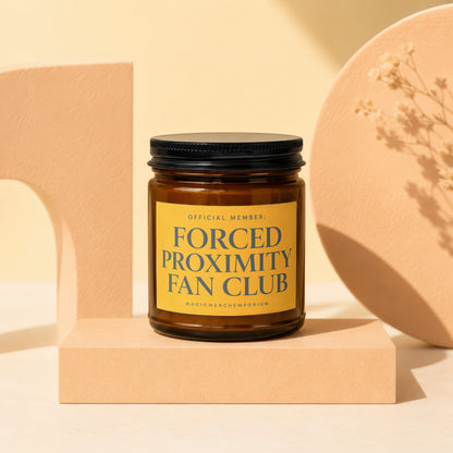 Amber jar candle with black lid for "Forced Proximity Fan Club".