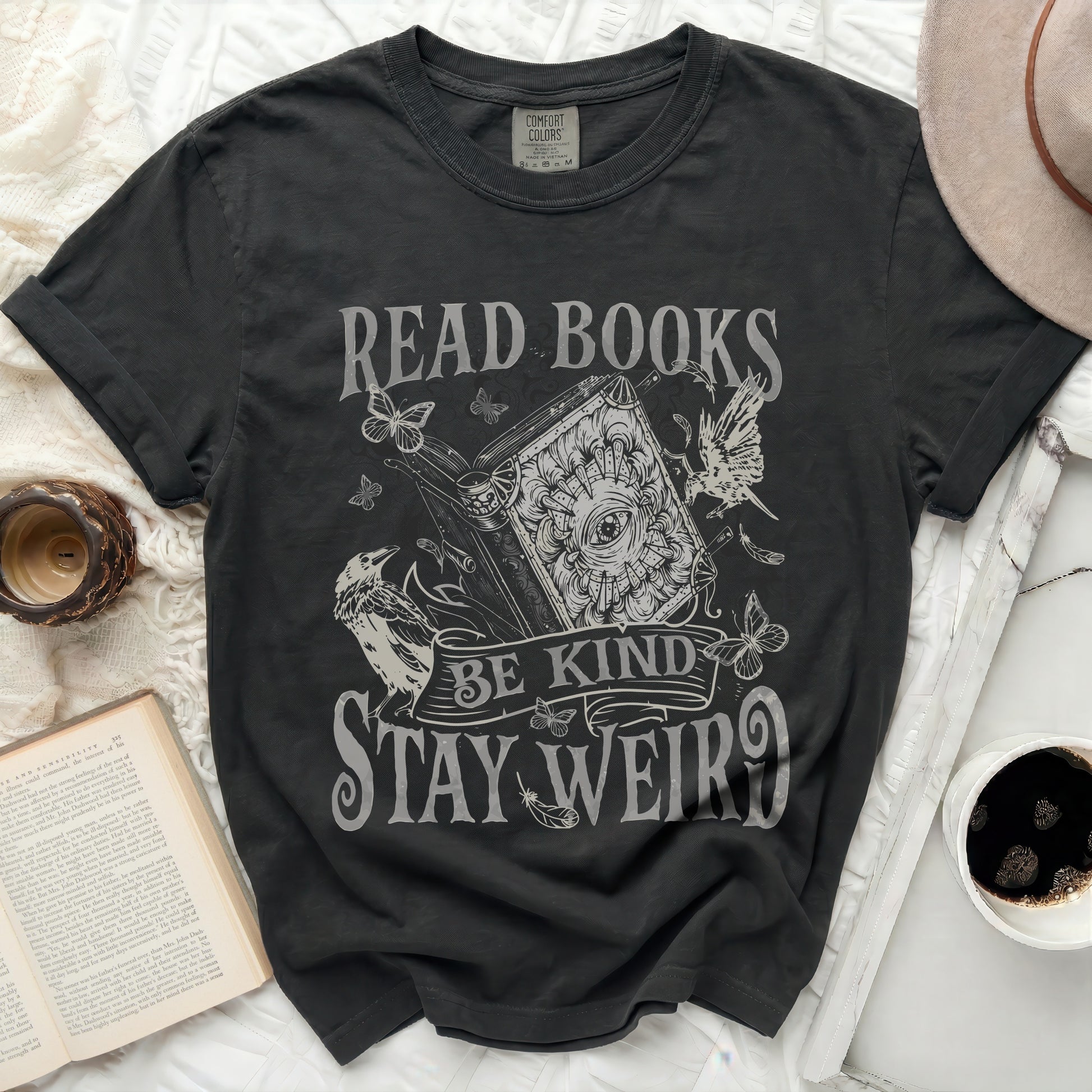 Black t-shirt with "Read Books Be Kind Stay Weird" text and vintage illustration.