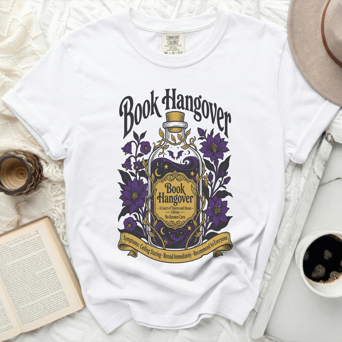 White t-shirt with "Book Hangover" design, a potion bottle, and symptoms.