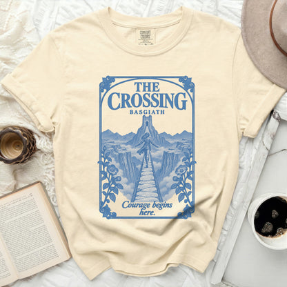 Cream t-shirt with blue graphic of a bridge and castle, reading "The Crossing Basgiath Courage begins here."