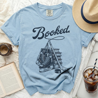 Light blue t-shirt with "Booked" and hockey skates, stick, and puck design.