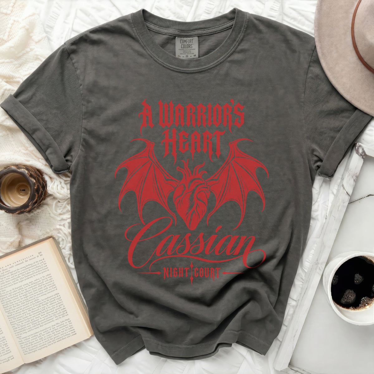 Gray t-shirt with red graphic of wings, heart, and text "A WARRIOR'S HEART Cassian NIGHT COURT".